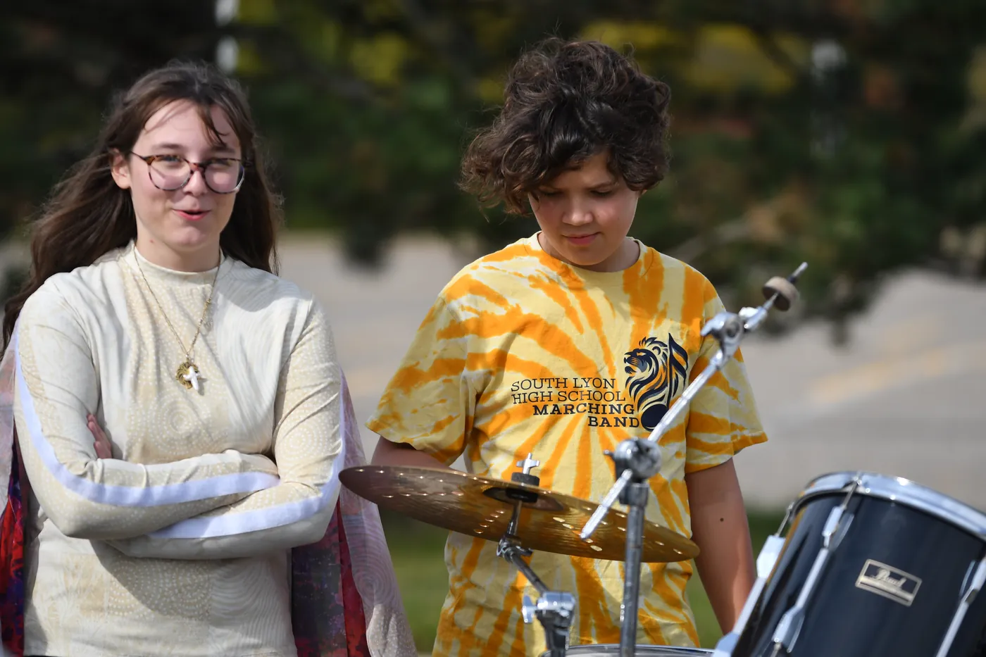Two South Lyon band students standing together by percussion equipment outdoors