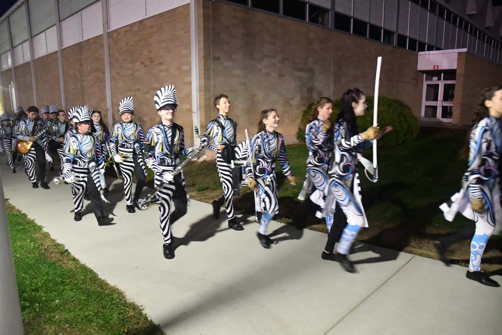 Marching Band and Color Guard students walking together to a performance in 2025