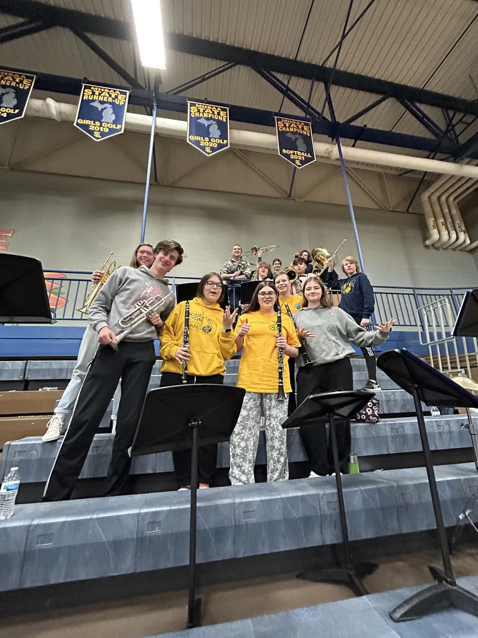 South Lyon High School Pep Band students with instruments in the gym bleachers in 2023