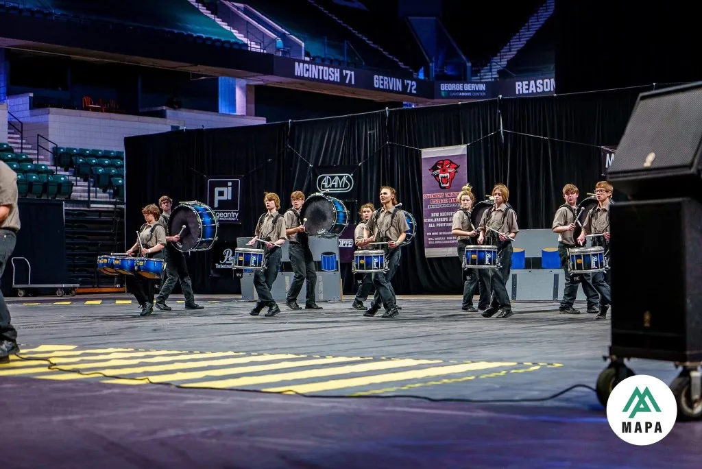 South Lyon Percussion students performing with marching drums at an indoor competition in 2023